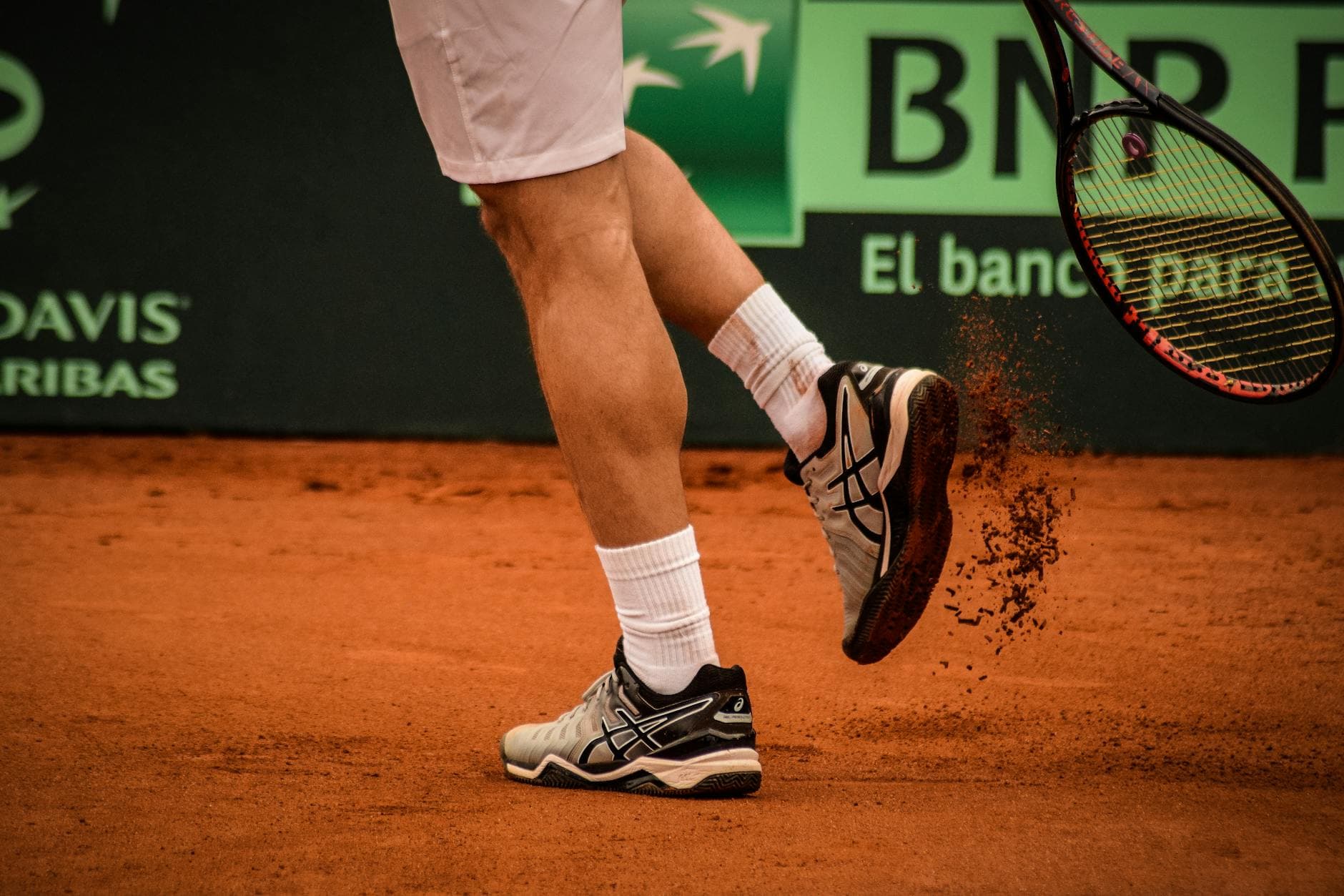 A tennis player with a brand in the background